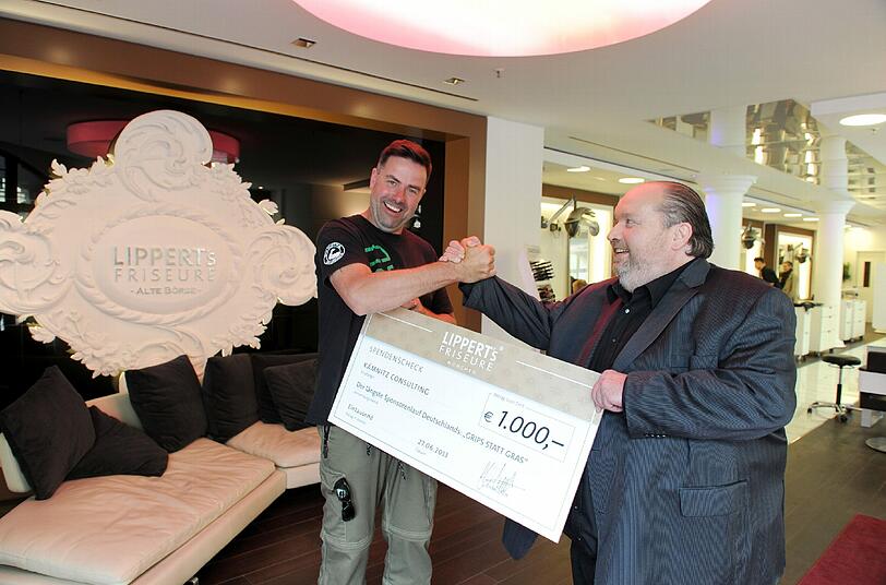 Schönes Spenden-Schmankerl: Star-Friseur Wolfgang Lippert gibt Kämnitz einen 1000-Euro-Scheck.