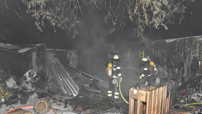 Einsatzkräfte der Feuerwehr neben dem ausgebrannten Kühlanhänger. Einsatzkräfte der Feuerwehr neben dem ausgebrannten Kühlanhänger.