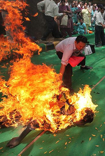 Auf einer Demonstration in Indien löscht ein Teilnehmer einen tibetischen Aktivisten, der sich selbst in Brand gesteckt hat.