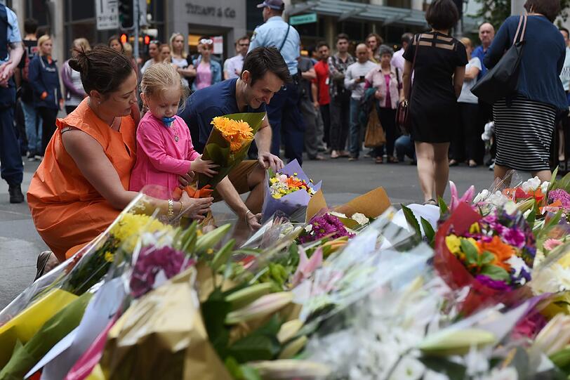 Tausende Menschen legen in der Nähe des "Lindt"-Cafés Blumen nieder.