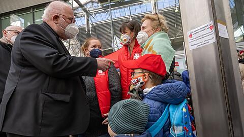 Kardinal Reinhard Marx (l.), Erzbischof von München und Freising, am Caritas-Infopoint für ukrainische Geflüchtete im Hauptbahnhof.