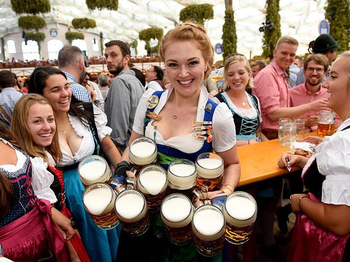 Die Wiesnbedienung Beli trägt im Hofbräuzelt die ersten Bierkrüge zu den Gästen.