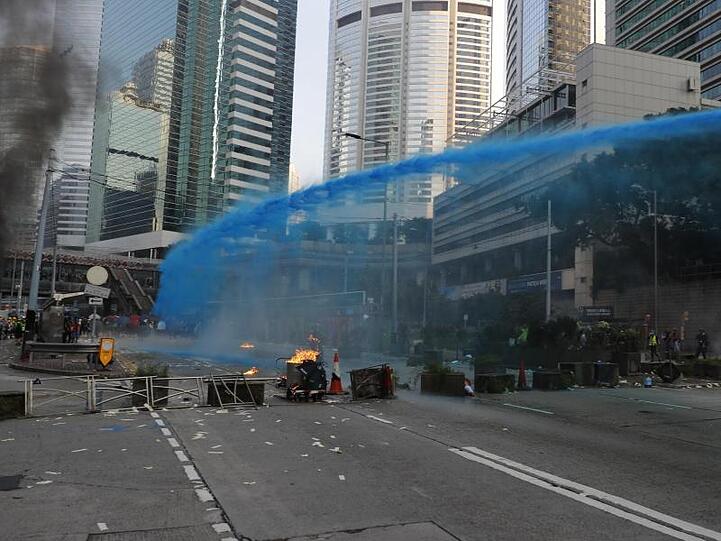 Die Polizei von Hongkong versprüht blau gefärbtes Wasser, um Demonstranten zu markieren.