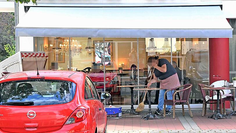 Eine Mitarbeiterin der Bäckerei kehrt nach dem Unfall die Scherben zusammen. Eine Mitarbeiterin der Bäckerei kehrt nach dem Unfall die Scherben zusammen.