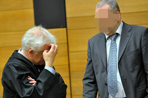 Der ehemalige Polizeichef von Rosenheim, Rudolf M. (r), steht zu Prozessbeginn in einem Sitzungssaal im Landgericht in Traunstein (Bayern) neben seinem Rechtsanwalt Andreas von Mariassy.