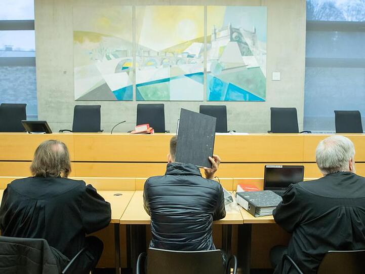 Ein wegen Kindesmissbrauchs angeklagter Logopäde (M) sitzt im Landgericht zwischen seinen Verteidigern. Foto: Daniel Karmann/dpa/Archivbild