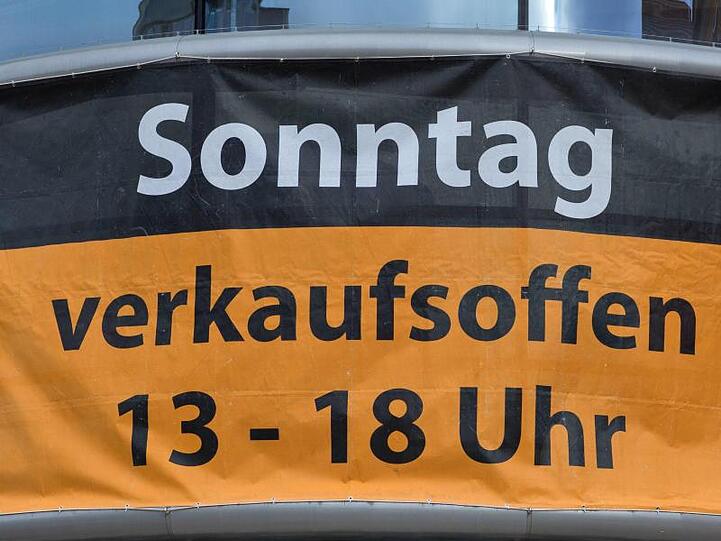 Ein Werbeposter informiert über die Öffnungszeiten an einem verkaufsoffenen Sonntag.