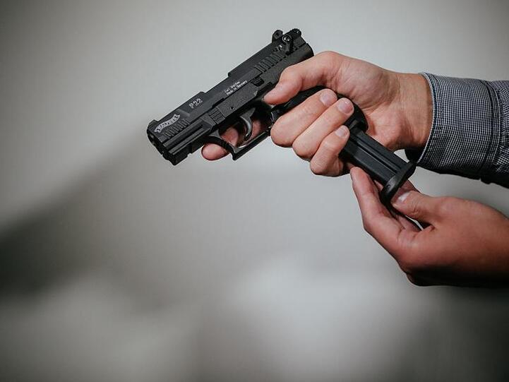 Hände laden eine Schreckschuss-Pistole "Walther P22" mit einem Magazin. Foto: Oliver Killig/Archivbild
