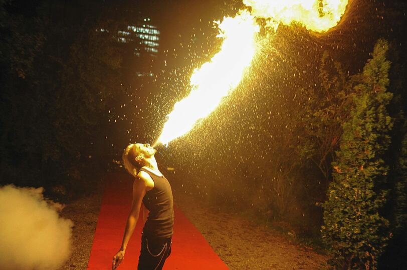 Ein Feuerspucker zeigt seine Künste.