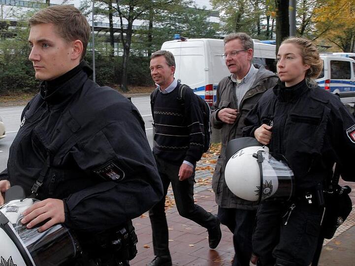 AfD-Mitbegründer Bernd Lucke (2.v.l.) verlässt nach seiner durch massive Proteste gestörten Antrittsvorlesung von Polizisten geschützt den Campus der Universität Hamburg.