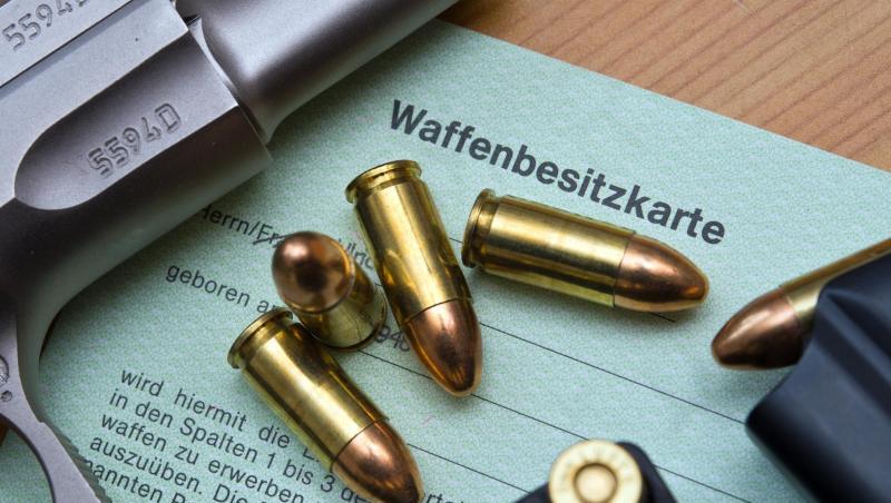 Eine Pistole und Patronen auf einer Waffenbesitzkarte. Eine Pistole und Patronen auf einer Waffenbesitzkarte.
