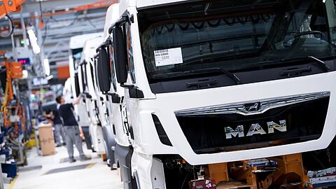 Mitarbeiter von MAN Truck & Bus arbeiten in einer Produktionsstraße.