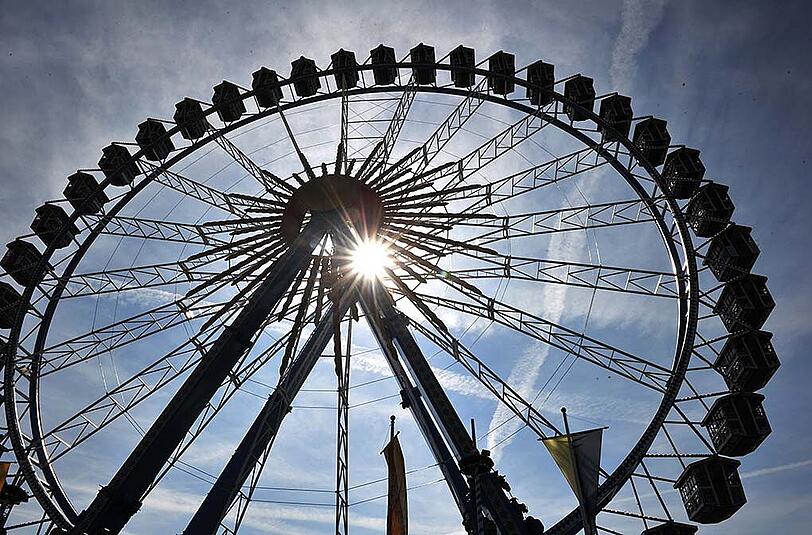 Die Sonne scheint durch's Riesenrad auf der Wiesn. Zum Wiesn-Start dürfen sich alle Besucher auf Sonnenschein und milde Temperaturen freuen.