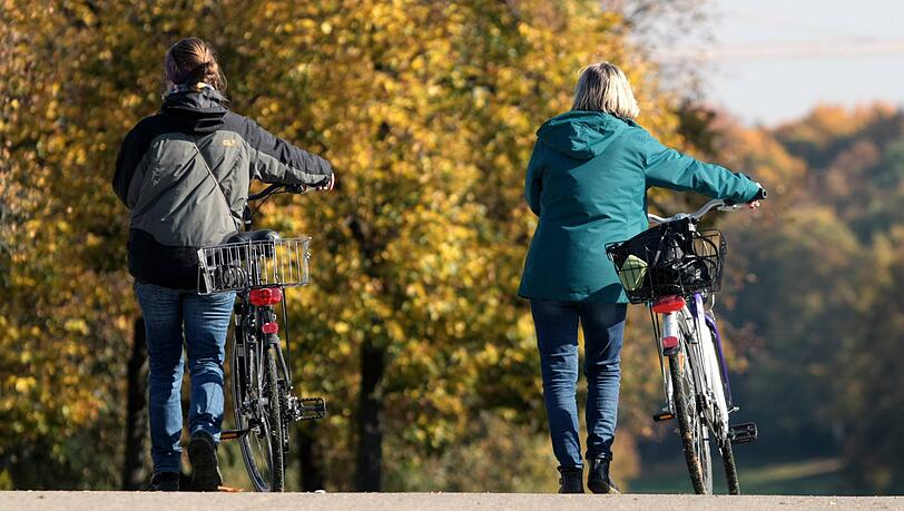 Frauen schieben ihr Fahrrad über eine Brücke im Westpark – ein seltenes Bild, gerade in Corona-Zeiten.