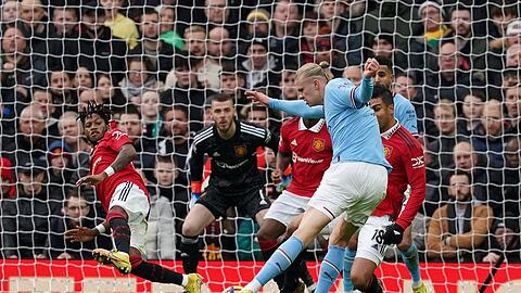 Fred von Manchester United (l) wirft sich in den Schuss von City-Stürmer Erling Haaland (vorne).