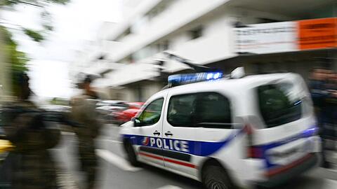 Ein Polizeiauto fährt zur Schule.
