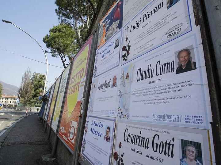Todesanzeigen auf einer Tafel am Rand einer leeren Straße in Alzano Lombardo unweit von Bergamo.