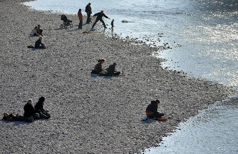 Und so sah es letztes Jahr aus: Menschen sitzen am 01.03.2012 an einem Strand an der Isar in München in der Sonne. Temperaturen um die 13 Grad herrschten damals am Tag des meteorologischen Frühlingsanfangs. Foto: Andreas Gebert dpa/lby