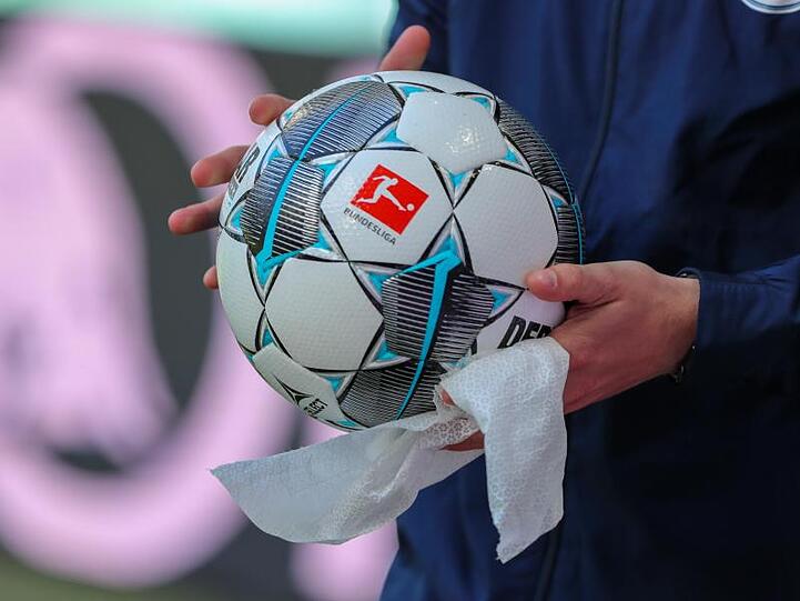 Ein Balljunge desinfiziert in Leipzig den Ball mit einem Tuch.