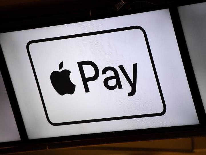 Hinweisschilder auf Apple Pay an einem Kiosk in der Münchener Allianz Arena.
