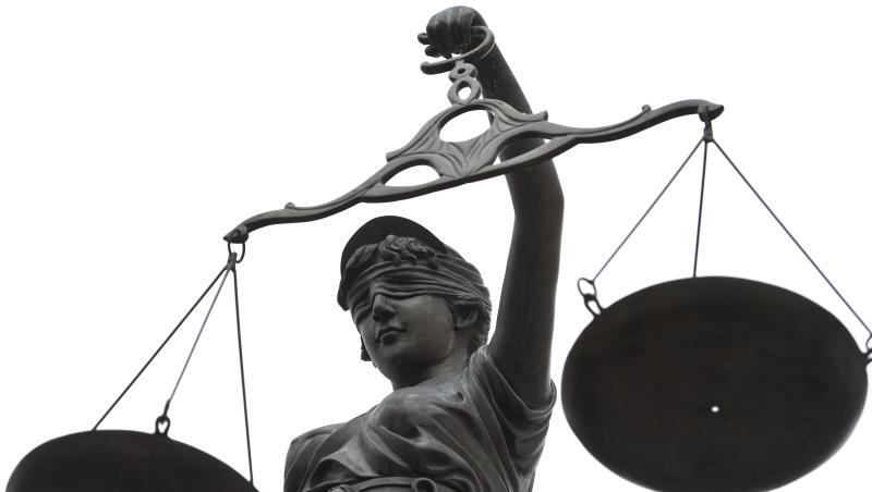 Eine Statue der Justitia mit einer Waage in ihrer Hand.