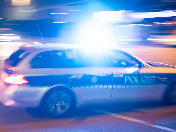 Ein Polizeiauto fährt unter Einsatz von Blaulicht und Sirene eine Straße entlang. Foto: Lino Mirgeler/dpa/Symbolbild