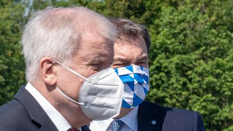 Horst Seehofer (CSU, l) und Markus Söder (CSU) tragen Mundschutz. Foto: Peter Kneffel/dpa