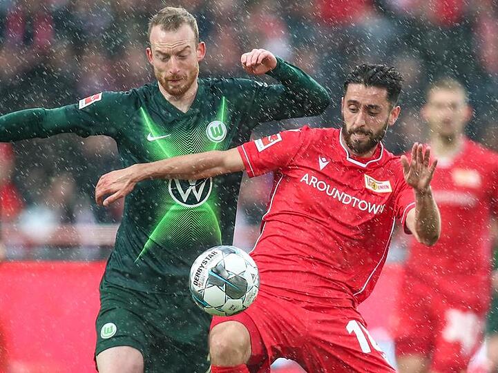 Wolfsburgs Maximilian Arnold (l) kämpft mit Unions Yunus Malli um den Ball.
