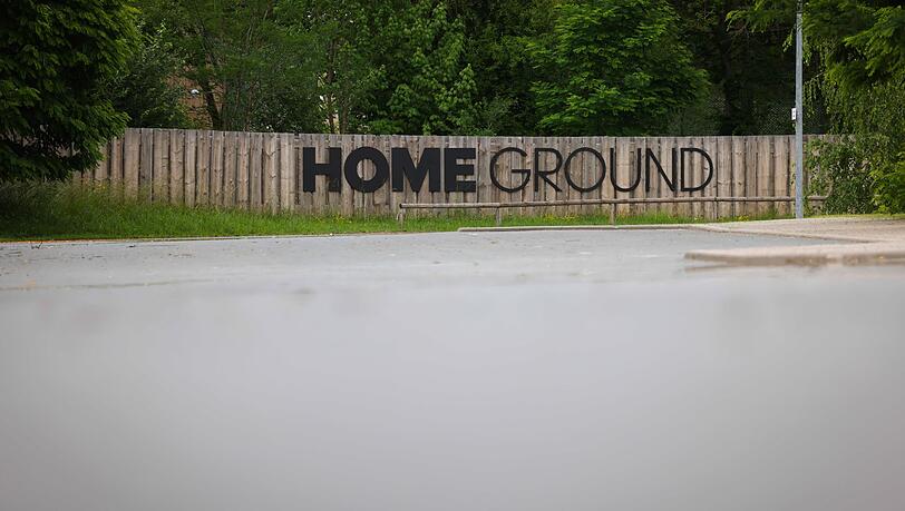 Der Schriftzug "Home Ground" steht auf einem Holzzaun.
