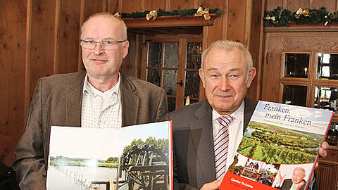 Günther Beckstein und Fotograf Erich Weiß (li.) präsentieren den Bildband "Franken, mein Franken". Das Schöpfrad bei Möhrendorf ist eines von Weiß' Lieblingsmotiven.