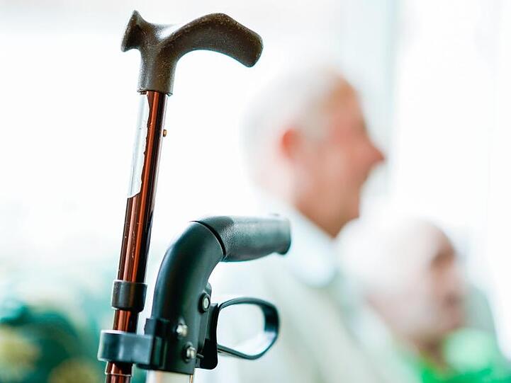 Ein Rollator und ein Gehstock stehen in einer Wohn-Pflege-Gemeinschaft.