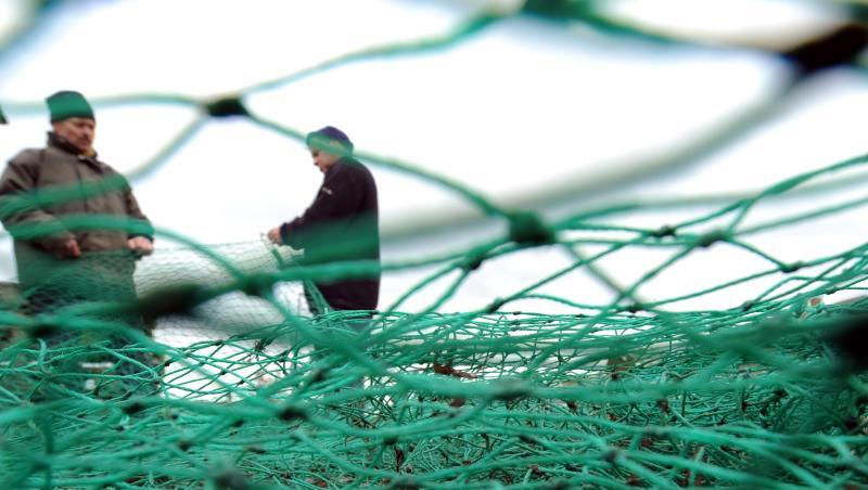 Fischer bereiten im Fischereihafen in Lübeck-Travemünde ihre Fangnetze für die nächste Fahrt vor.