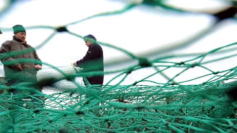 Fischer bereiten im Fischereihafen in Lübeck-Travemünde ihre Fangnetze für die nächste Fahrt vor.