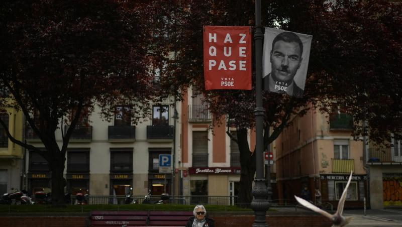 Eine Frau sitz auf einer Bank neben einem Wahlbanner für Sanchez, der spanische Ministerpräsident, mit dem Satz, "Mach es möglich". Sanchez liegt zwar in Umfragen seit Wochen mit rund 30 Prozent vorne. Eine Frau sitz auf einer Bank neben einem Wahlbanner für Sanchez, der spanische Ministerpräsident, mit dem Satz, "Mach es möglich". Sanchez liegt zwar in Umfragen seit Wochen mit rund 30 Prozent vorne.