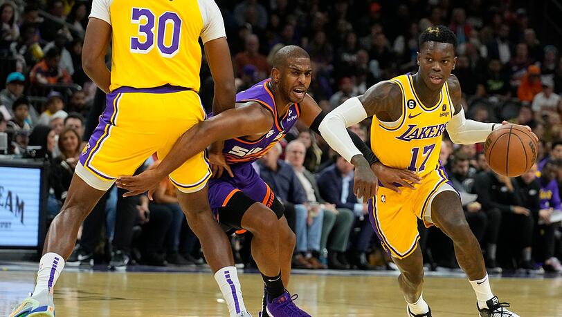 Lakers-Guard Dennis Schröder (17) zieht an Suns-Guard Chris Paul (M) vorbei, während Lakers-Center Damian Jones (30) einen Pick setzt.