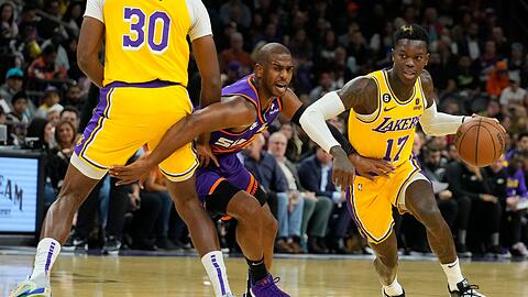 Lakers-Guard Dennis Schröder (17) zieht an Suns-Guard Chris Paul (M) vorbei, während Lakers-Center Damian Jones (30) einen Pick setzt.