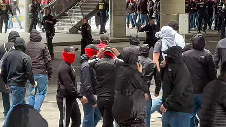 Polizisten (hinten, Mitte) gehen gegen vermummte, gewaltbereite Fans vor. Rivalisierende Fu&szlig;ballfans des VfB Stuttgart und des FC Bayern M&uuml;nchen haben sich in M&uuml;nchen eine Massenschl&auml;gerei geliefert.