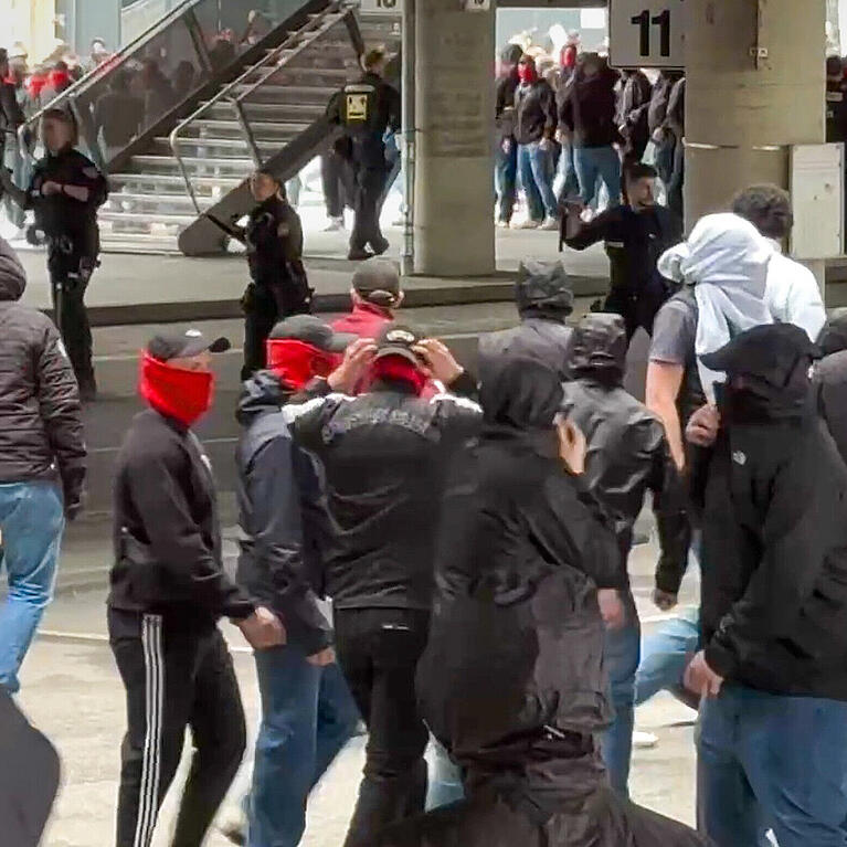 Polizisten (hinten, Mitte) gehen gegen vermummte, gewaltbereite Fans vor. Rivalisierende Fu&szlig;ballfans des VfB Stuttgart und des FC Bayern M&uuml;nchen haben sich in M&uuml;nchen eine Massenschl&auml;gerei geliefert.