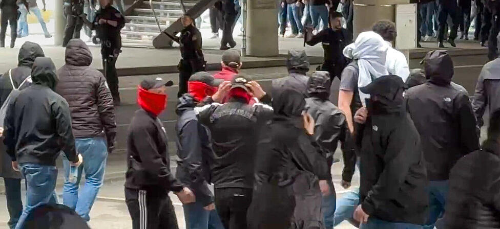 Polizisten (hinten, Mitte) gehen gegen vermummte, gewaltbereite Fans vor. Rivalisierende Fu&szlig;ballfans des VfB Stuttgart und des FC Bayern M&uuml;nchen haben sich in M&uuml;nchen eine Massenschl&auml;gerei geliefert.