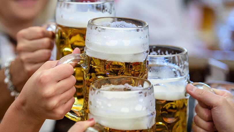 Besucher stoßen auf dem Oktoberfest mit Bier an.