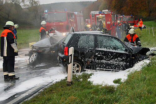 Die Feuerwehr löscht die Flammen am Opel Corsa (hinten), auch der VW Lupo der Unfallgegnerin ist nur noch Schrott.