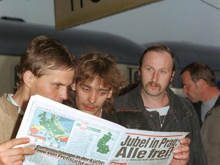 DDR-Übersiedler lesen nach ihrer Ankunft am 1.10.1989 in Hof eine Zeitung. Foto: Martina Hellmann/Archivbild