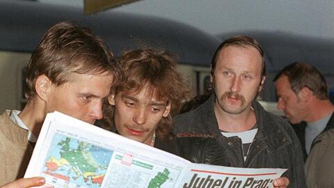 DDR-Übersiedler lesen nach ihrer Ankunft am 1.10.1989 in Hof eine Zeitung. Foto: Martina Hellmann/Archivbild