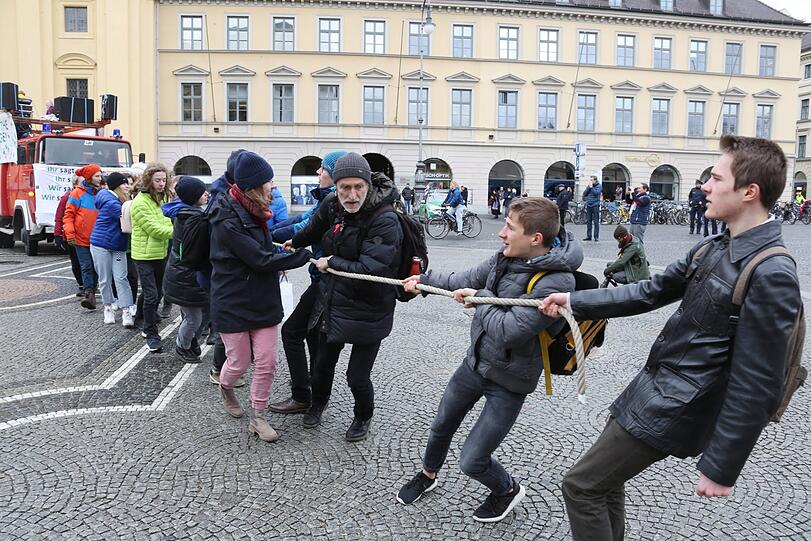 Die Demonstranten von Fridays for Future ziehen ihr Protestmobil an einem Seil an der Staatskanzlei vorbei bis zum Isartor.