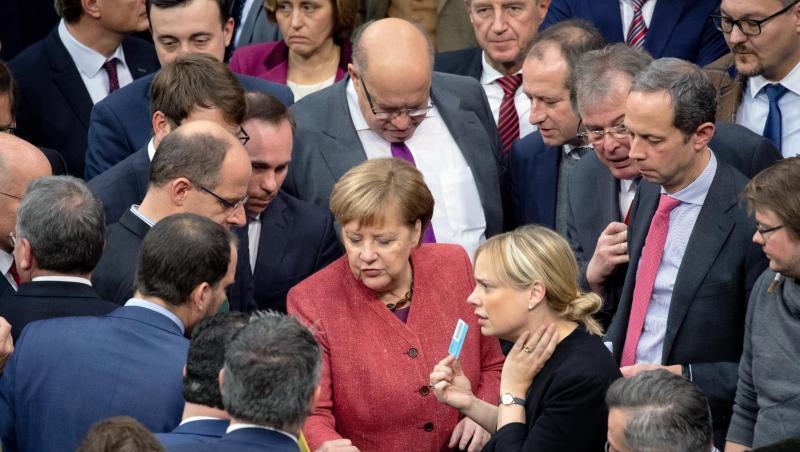 Bundeskanzlerin Angela Merkel (M) gibt bei der namentlichen Abstimmung über den UN-Migrationspakt ihre Stimmkarte ab. Bundeskanzlerin Angela Merkel (M) gibt bei der namentlichen Abstimmung über den UN-Migrationspakt ihre Stimmkarte ab.