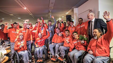 Athleten der deutschen Paralympics-Mannschaft stehen und sitzen nach ihrer Rückkehr aus Pyeongchang auf dem Frankfurter Flughafen zu einem Gruppenfoto beisammen.