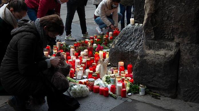 Trauernde legen am Morgen nach der Amokfahrt mit fünf Toten in Trier an der Porta Nigra Kerzen und Blumen nieder.