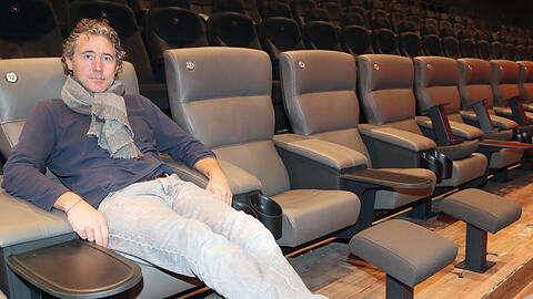 Kino-Chef Michael Wohlgemuth in einem der bereits fertig installierten Premiumsitze. Sie sind aus Leder, können leicht zurückgeklappt werden und haben eine Fußstütze sowie kleine Tische integriert.