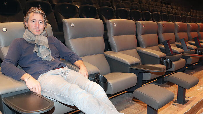 Kino-Chef Michael Wohlgemuth in einem der bereits fertig installierten Premiumsitze. Sie sind aus Leder, können leicht zurückgeklappt werden und haben eine Fußstütze sowie kleine Tische integriert.