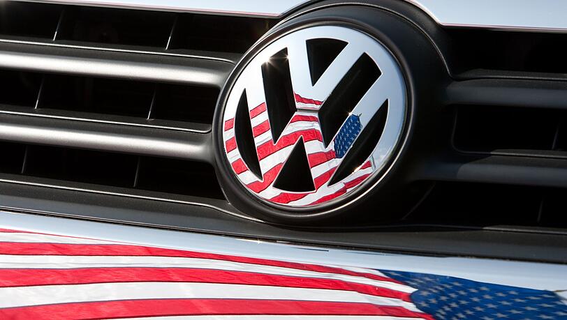 Die US-Fahne spiegelt sich in Logo und Kühlergrill eines Volkswagen-Fahrzeugs.